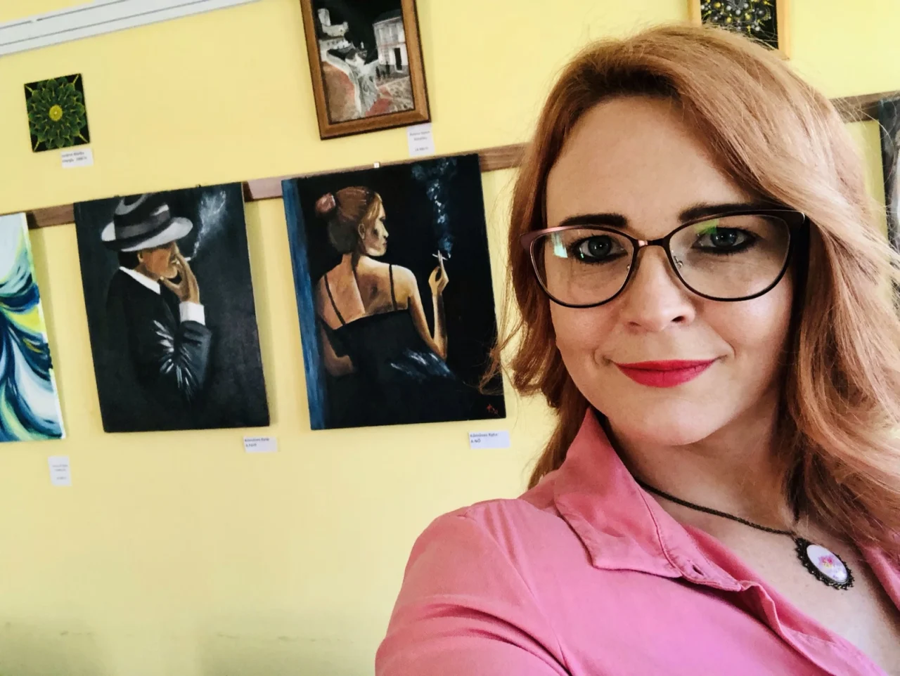 Kőműves Kata egy korábbi kiállításán saját festményei előtt